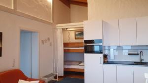 a kitchen with white cabinets and a microwave at Fewo Alpenpanorama in Hohenpeißenberg