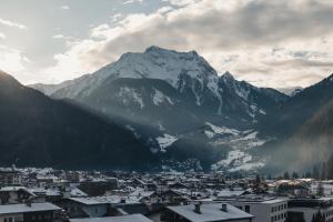 a view of a city with a snow covered mountain at MANNI das Hotel in Mayrhofen