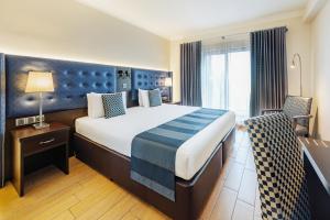 a hotel room with a large bed and a window at AX The Victoria Hotel in Sliema