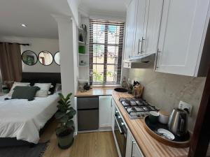 约翰内斯堡The Bryanston Boutique的一间厨房,配有白色的橱柜和一张位于客房内的床