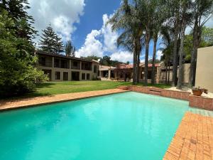 约翰内斯堡The Bryanston Boutique的房子前面的一个蓝色大游泳池 更多36张照片