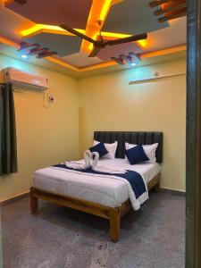 a bedroom with a bed with a ceiling with lights at Sunrise Home Stay in Tirupati