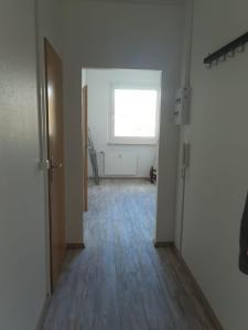 an empty room with a window and a wooden floor at 2 Bett Monteurwohnung in Zeithain in Zeithain