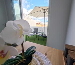 大加那利岛拉斯帕尔马斯Violeta Suite的一张桌子上,桌子上放着白色花朵,上面放着雨伞