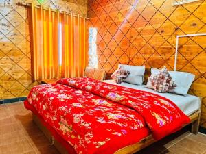 una camera da letto con un letto con una coperta rossa di Hotel Himalayan View a Chakrāta
