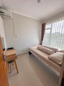 a bedroom with a bed and a window at Villa FiFa in Blimbing