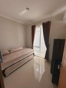 a bedroom with a bed and a large window at Villa FiFa in Blimbing