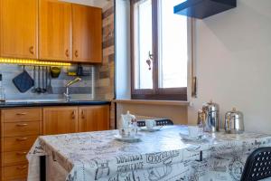 a kitchen with a table with a table cloth on it at Rododendro 29 - Ciclovia Alpe Adria APT with Terrace in Tarvisio +23 photos