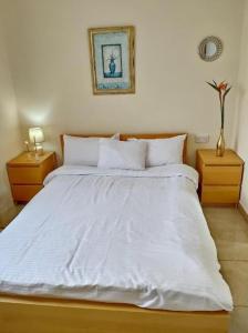 a bed with white sheets and pillows in a bedroom at SWEET HOME CORAL BAY, Sea view, Coral Bay, near beach in Peyia