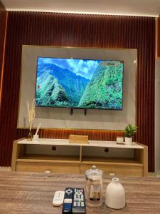 TV de pantalla plana en una pared con mando a distancia en Ultimate luxury Apt in JLT, en Dubái