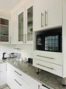 a kitchen with white cabinets and a counter top at Omaha Luxury B&B & SPA in Mthatha
