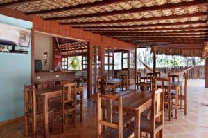 a dining room with wooden tables and chairs at Pousada Vila Icaraí in Icaraí