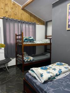 Cette chambre comprend 2 lits superposés et une chaise. dans l'établissement Kitnet Girassol, à São Thomé das Letras