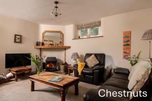 Una sala de estar con un sofá y una chimenea. en The Old Rectory Cottages - Six Luxurious Cottages Set In Grounds With Indoor Pool, en Kings Nympton
