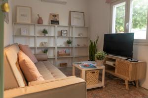 a living room with a couch and a television at Casa do Pátio do Tejo N12 in Sarilhos Pequenos