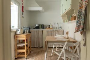 a small kitchen with a wooden table and chairs at Casa do Pátio do Tejo N12 in Sarilhos Pequenos
