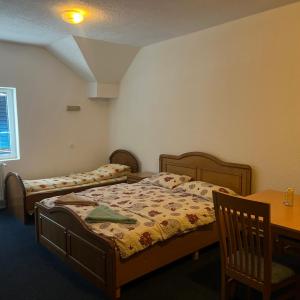 佩奇Hotel Gryka的一间卧室，有两张床、一张书桌和一张桌子