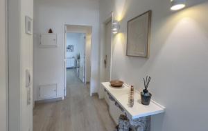 einen Flur mit weißen Wänden und einem weißen Tisch mit einer Vase in der Unterkunft Casa AL Reis in Faro + 38 Fotos