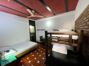a room with two beds and a ceiling fan at Sana Mar Hostel & Eco-Café in Santa Marta +42 photos