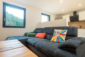 ein Wohnzimmer mit einem Ledersofa und einem Fenster in der Unterkunft Gîte pour 4 personnes - Le Grand Valtin, à 2 pas de Xonrupt in Ban-sur-Meurthe-Clefcy + 34 Fotos