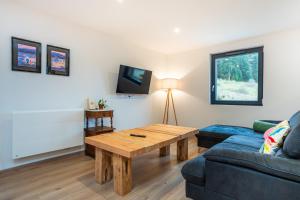 ein Wohnzimmer mit einer Couch und einem Couchtisch in der Unterkunft Gîte pour 4 personnes - Le Grand Valtin, à 2 pas de Xonrupt in Ban-sur-Meurthe-Clefcy