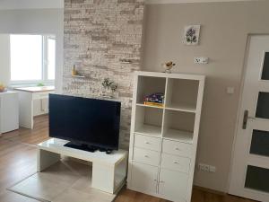 a white entertainment center with a flat screen tv in a living room at Apartmán U Rybníčku in Loučná nad Desnou