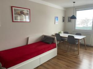 a bedroom with a bed and a table with chairs at Apartmán U Rybníčku in Loučná nad Desnou