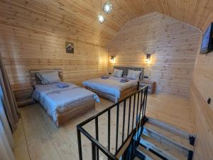 a room with two beds in a wooden cabin at cottage nikolozi in Kazbegi