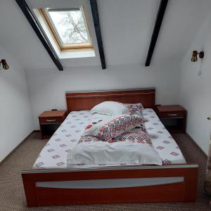 a bedroom with a bed with two night stands and a window at Apartament Laura in Bran