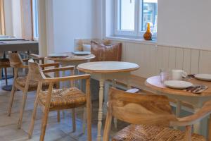 a dining room with tables and chairs and a table at Hostal Boutique Es Portalet in Sant Feliu de Guixols