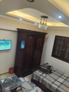 亚历山大Modern Entire studio, few steps from the sea with garden view Balcony and Free Wi Fi in Alexandria的带床和木柜的卧室