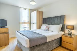 ein Schlafzimmer mit einem großen Bett und einem Fernseher in der Unterkunft Cotels at Vizion Serviced Apartments, Superfast Broadband, Central Location, Free Parking, Fully Equipped Kitchen in Milton Keynes + 28 Fotos