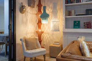 a living room with a couch and a chair and lights at Hostal Boutique Es Portalet in Sant Feliu de Guixols +28 photos