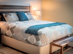 a bedroom with a bed with a blue blanket on it at Meerkat Manor Self-Catering & Accommodation Windhoek in Windhoek