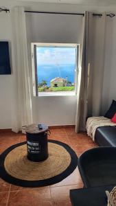 ein Zimmer mit einem Eimer auf dem Boden vor einem Fenster in der Unterkunft Bougainvillea House in Ponta do Pargo + 20 Fotos