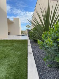 a house with a grassy yard next to a house at La villa Kalima T3 in Sérignan