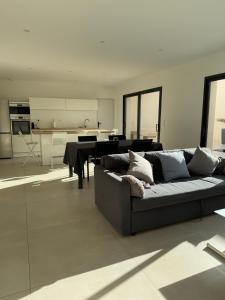 a living room with a couch and a table at La villa Kalima T3 in Sérignan