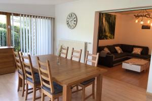 a dining room and living room with a wooden table and chairs at Gite des Hauts Jardins in Fraize