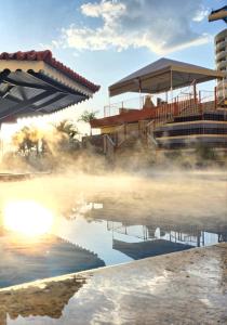 um lago enevoado com um edifício ao fundo em Parque das Águas Quentes em Caldas Novas