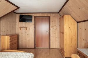 una camera da letto con pareti in legno e una porta con televisore di U Trabanta - noclegi, wycieczki jednodniowe, wypożyczalnia narciarska a Bukowina Tatrzańska