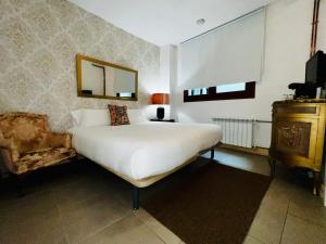 a bedroom with a bed and a mirror and a chair at Santa Rita Rita B&Boutique in Talavera de la Reina +38 photos
