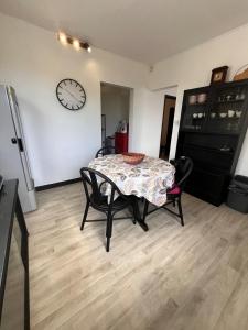 a dining room with a table and a clock on the wall at Appartement Lili in Grand-Baie