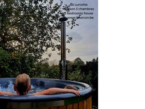 a couple of people sitting in a hot tub at Holiday home le Lurçon et la Lurcette in Libin