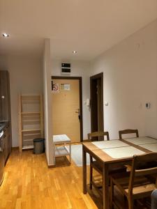 Una habitación con una mesa y sillas y una cocina. en BRZECE SKI GONDOLA & FREE PARKING apartment, en Kopaonik 10 fotos más