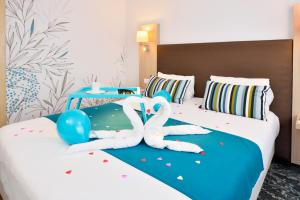 two people laying on a bed in a hotel room at Hotel Lille Europe in Lille