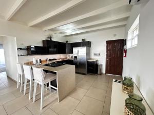 a kitchen with a counter and some chairs in it at Eden Beach Resort - Bonaire in Kralendijk
