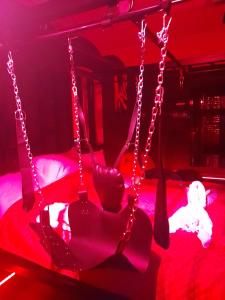 a swing in a red room with a teddy bear at Apartament Grey in Tuchola