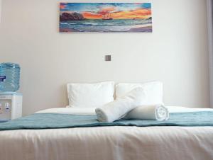 a bed with towels on it with a painting on the wall at Nanic Homes Executive Studio in Marimbeti