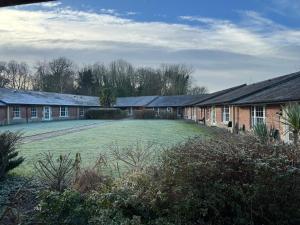 a row of houses with a large grass yard at Caradoc Country Cottages in Shrewsbury
