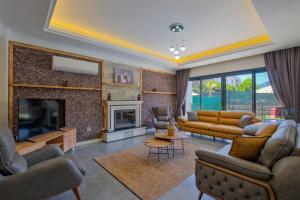 Una sala de estar con sofás y chimenea. en Villa White Palm 1, en Fethiye